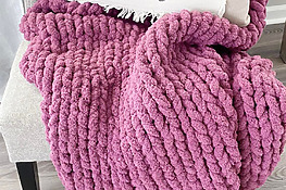 DIY chunky hand-knit blanket on a chair