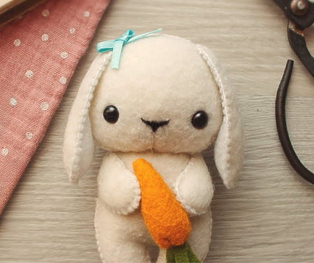Tiny Craft World Bunny: A small, plump felt bunny holding a tiny orange felt carrot