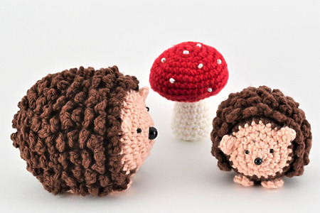 crochet hedgehogs in two sizes and a crochet mushroom