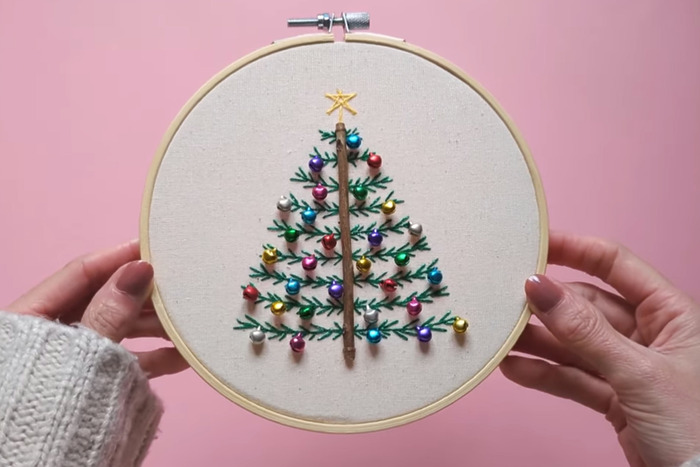 DIY Christmas tree embroidery hoop with a twig for the tree trunk and little colorful bells as ornaments