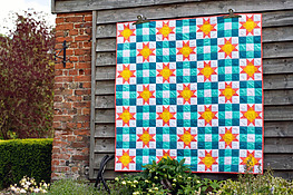 modern throw quilt with a basic nine patch block and the classic Ohio Star block