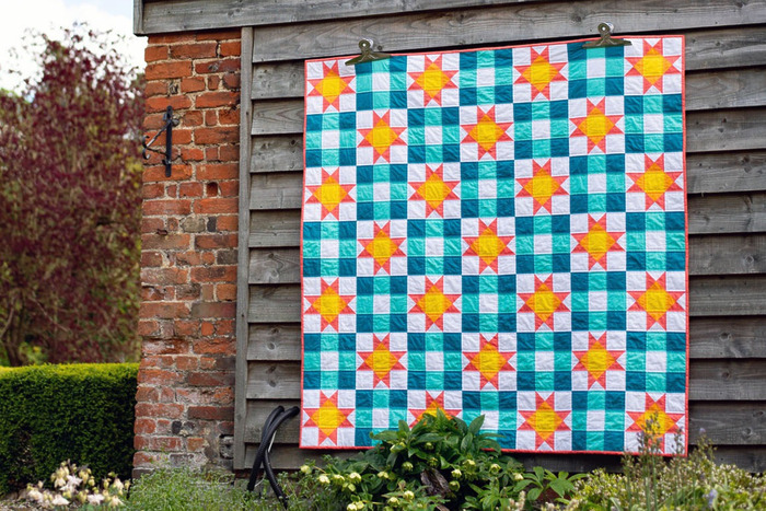 modern throw quilt with a basic nine patch block and the classic Ohio Star block