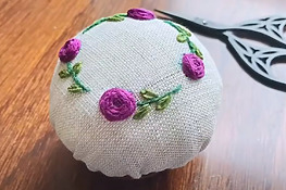 DIY hand embroidered pincushion with small flowers and leaves