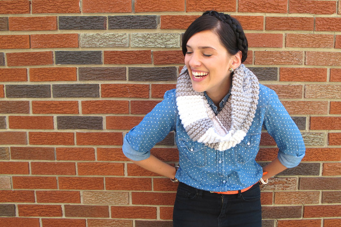 young woman laughing and wearing a simple garter stitch knitted cowl