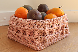 DIY Waffle Stitch Crochet Basket holding fruit on a counter