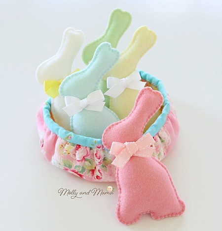 Molly and Mama Bunny: Several colorful felt bunnies with ribbon bows around their necks arranged on a table