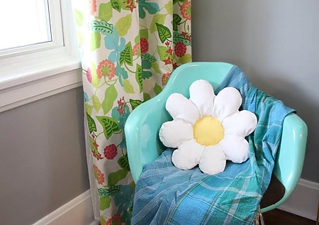 Daisy Pillow: A round white and yellow decorative cushion designed to look like a giant 70s style daisy