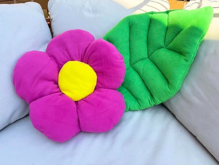 pink and yellow flower fabric pillow cushion and leaf cushion on a sofa