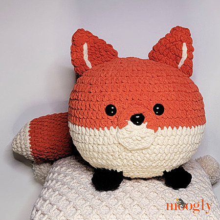 Fox Squish: A large, round, and squishy crocheted fox pillow made with thick blanket yarn, featuring minimalist facial features and soft ears